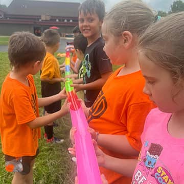 students working together with a small plastic chute