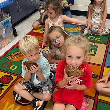 Students sitting in class with some coconut halves