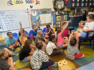 Students raising their hands in class