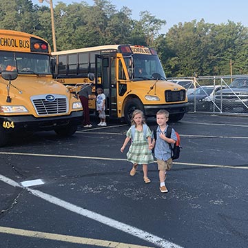 Students getting off the bus to go into school