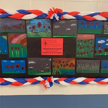Student drawings of red poppies displayed in the hallway