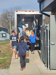 Student council getting food loaded into a truck for a donation project