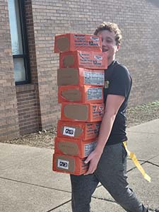 Student council member holding food to load onto the truck