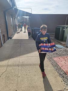 Students carrying food down the walkway outside