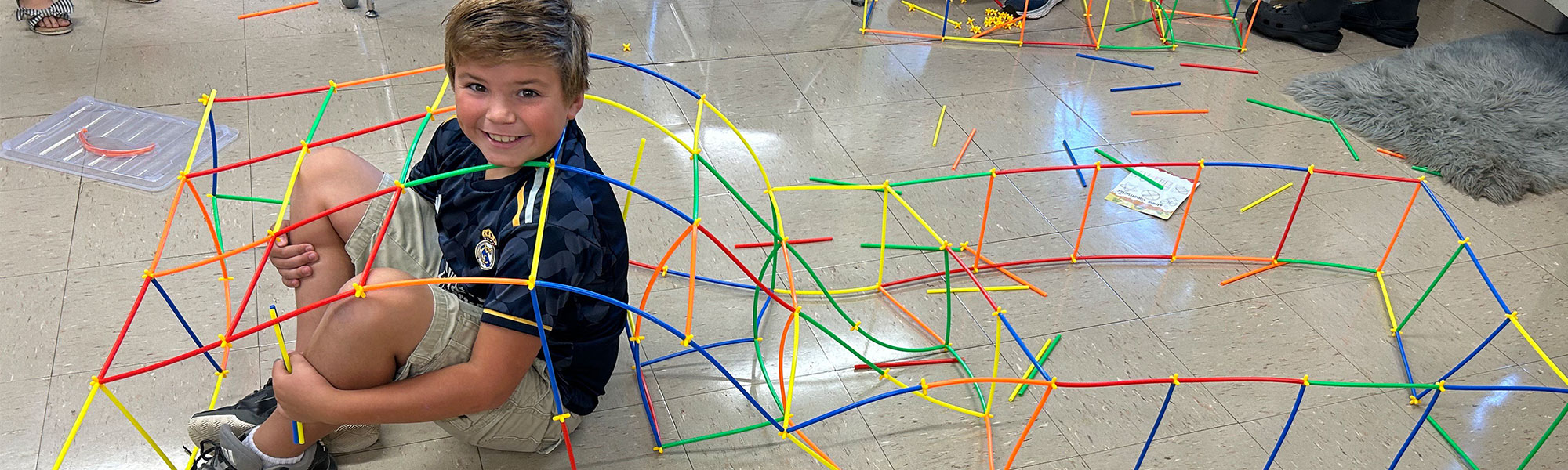 Boy inside of a giant stick structure he built