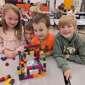 Students building structure with connecting counting blocks