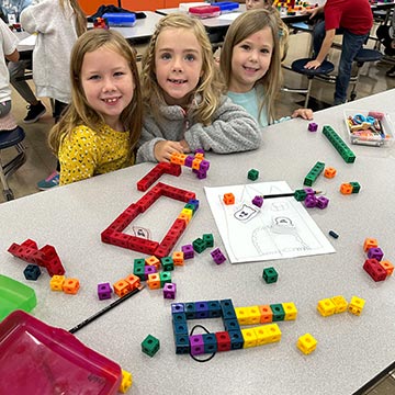 Three girls smiling in class