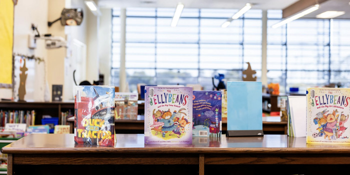 Children's books displayed on top of a book shelf