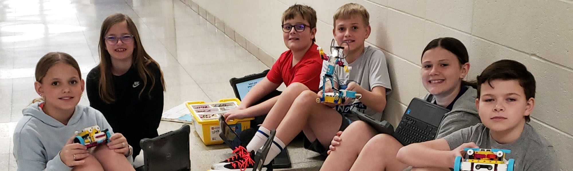 Group of happy students working together on robot projects