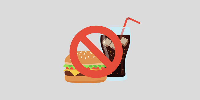 Drawing of a mamburger and glass of soda with a big red banned sign on top