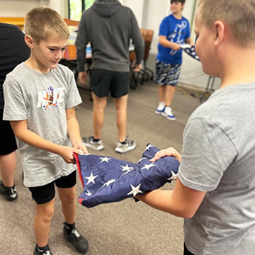 Two student folding the USA flag