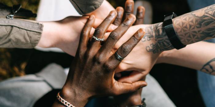 Different hands clasping together