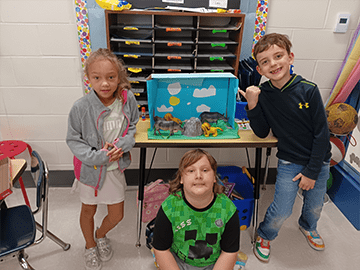 Three students showing their projects