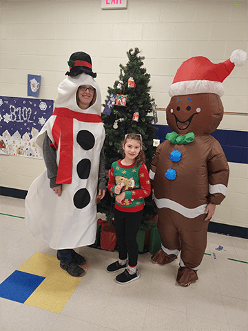 Student with an inflatable snowman and gingerbread costume