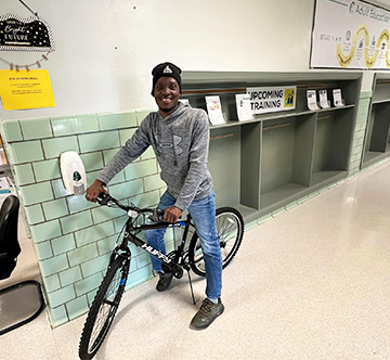 Happy student posing for a picture with his bike