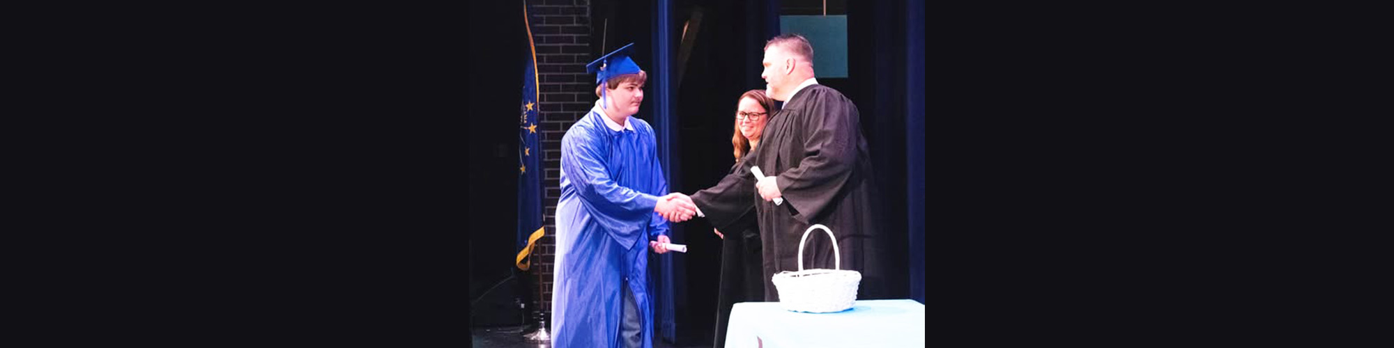 Student shaking hands and receiving his diploma