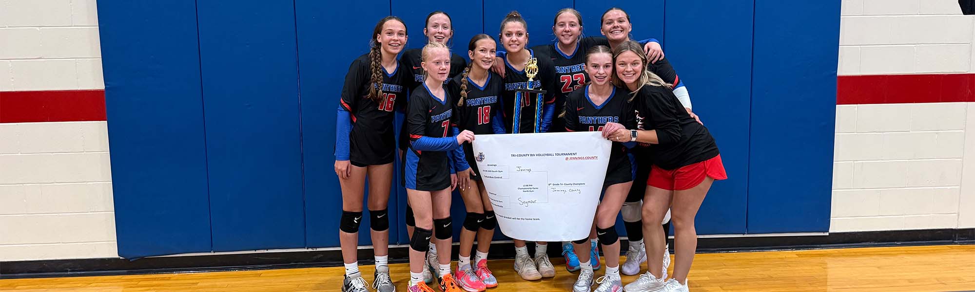 Girls volleyball team holding trophies