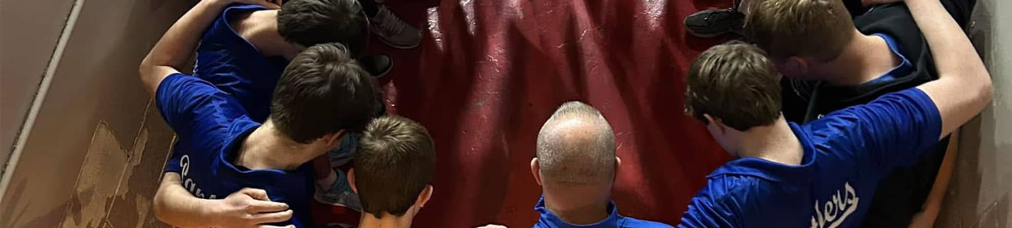 Athletes praying with coach