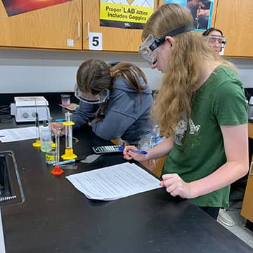 students wearing goggles working in the lab