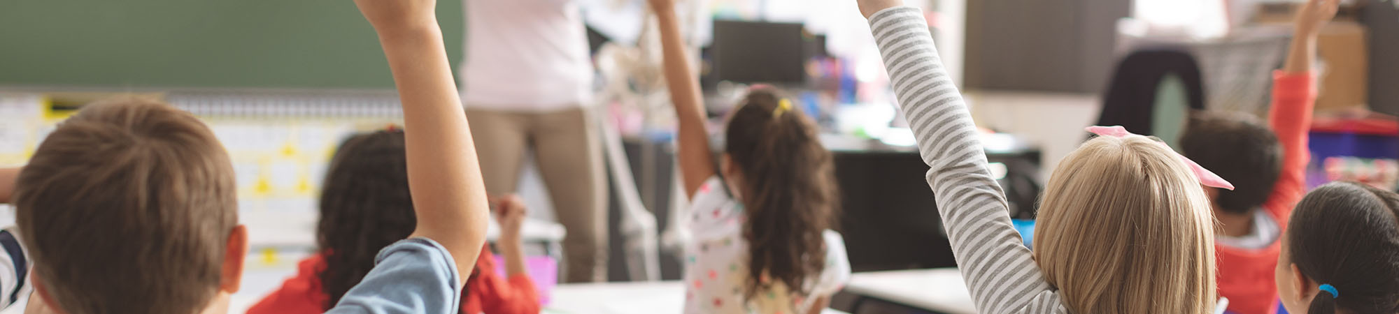Students raising their hands in the classroom