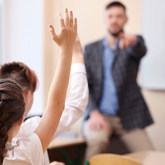 Male teacher calling on a student in the classroom