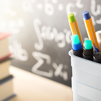 Math equations on a board and pencils
