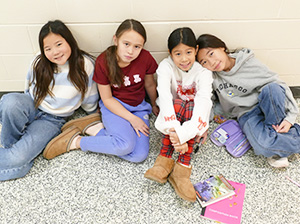 Happy girls sitting in the school hallway