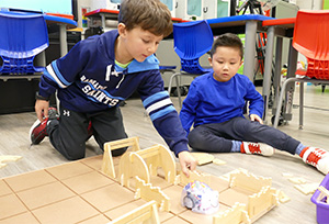Two boys playing with building blocks