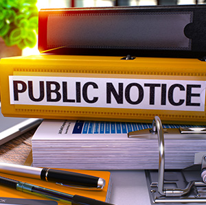 stack of notebooks with one that says Public Notice