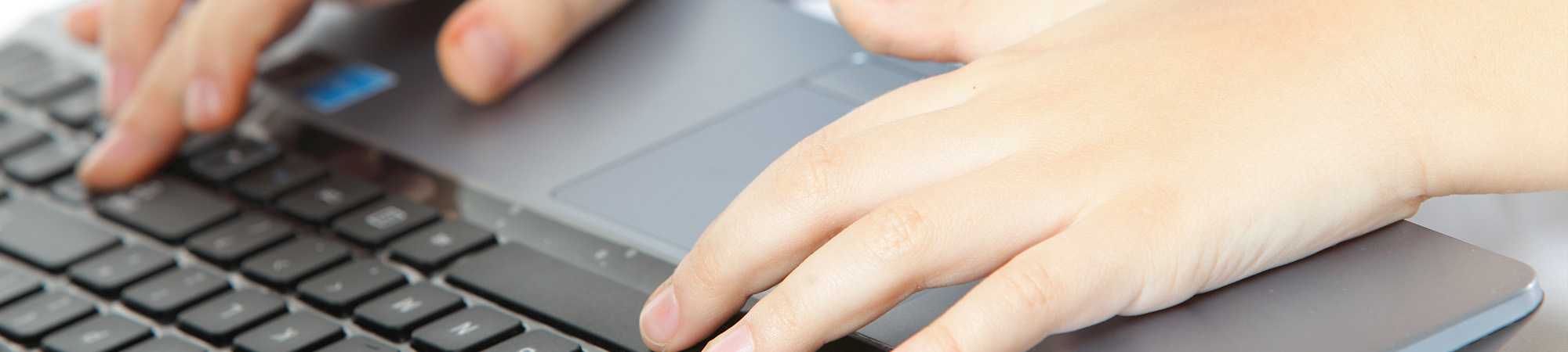 boys hands typing on a laptop