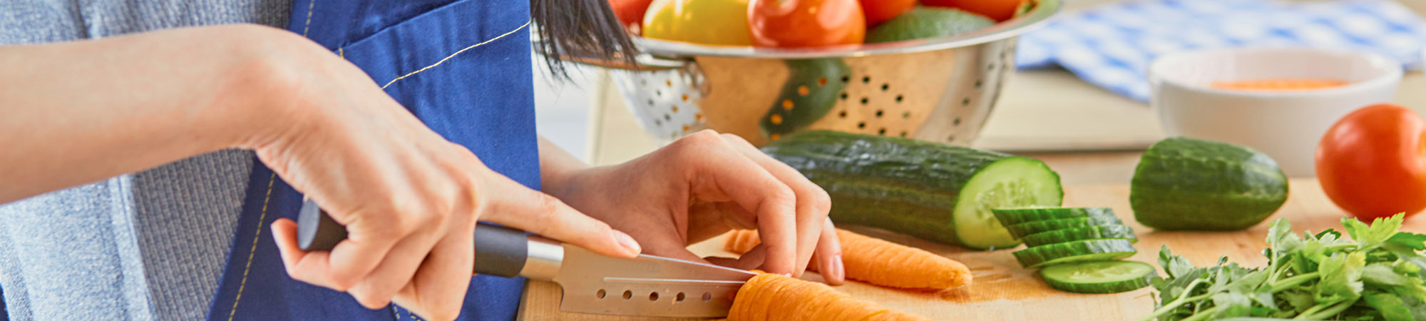 Kitchen worker slicing a carrot