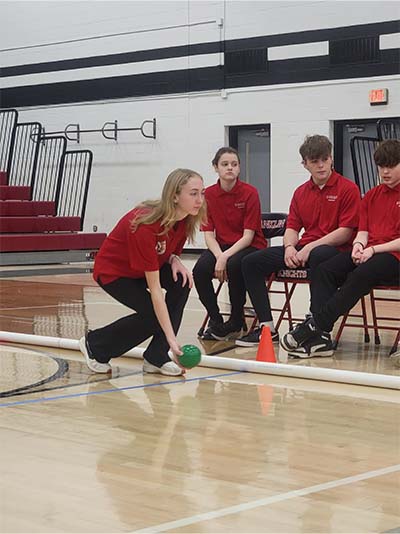 female student rolling a bocceball