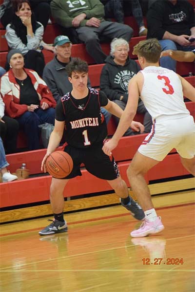 boy in black dribbling past a boy in white