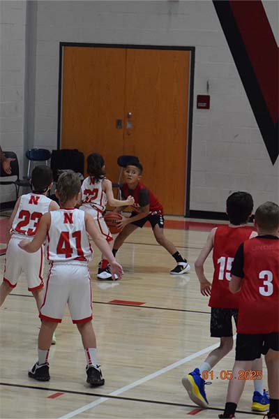 young boy in red dribbling