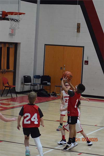 young boy in red shooting