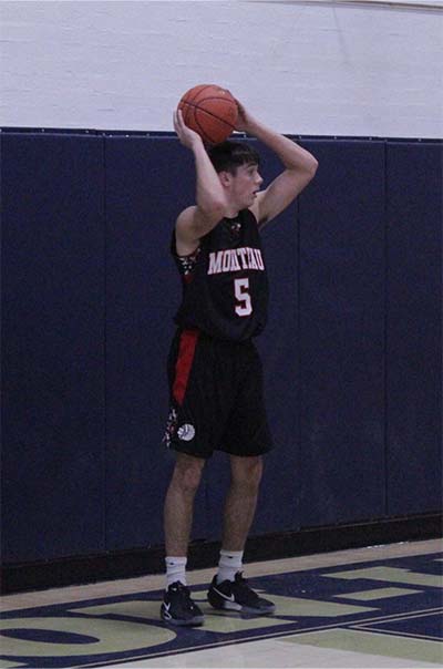 boy in black jersey passing the ball in