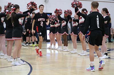 boys basketball team walking by cheerleaders