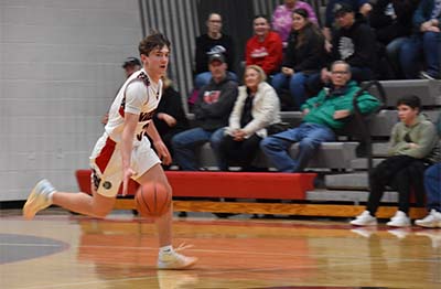 student in white dribbling and running