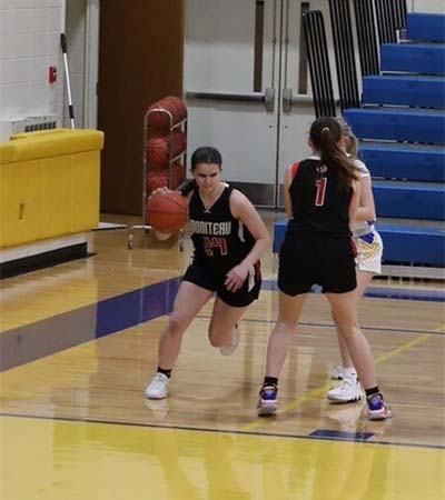 Girl in black setting a screen for her teammate