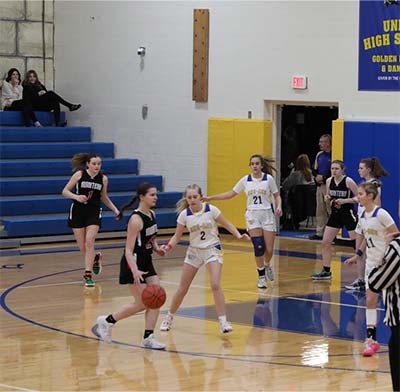 Girl in black dribbling looking for a pass