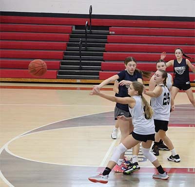 girls reaching for basketball