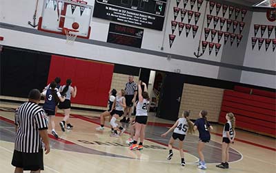 Girl in gray shooting a basketball