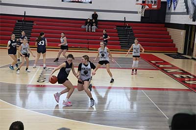 Girl in black jersey dribbling