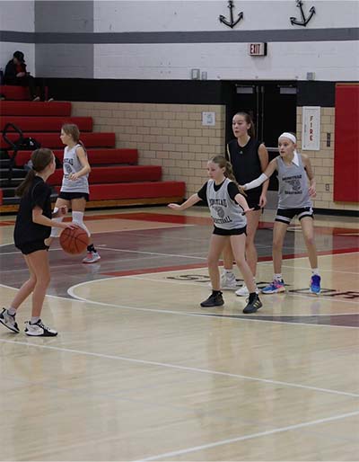 Girl in black dribbling looking for a pass