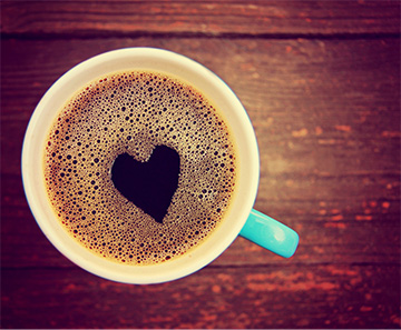 Cup of coffee with heart shape in the foam