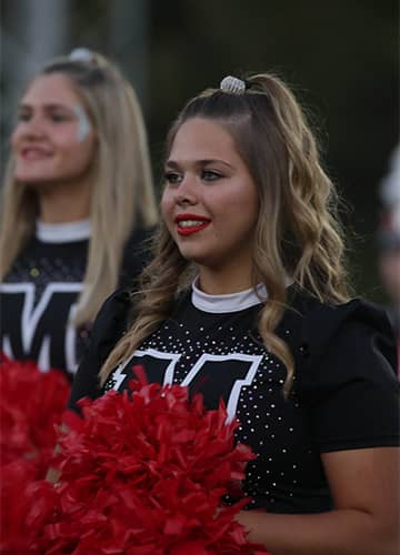 Cheerleader holding pom poms