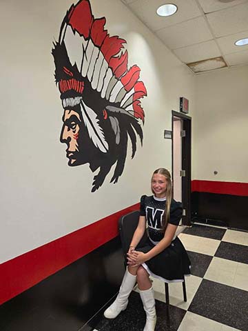 Cheerleader sitting in front of a mural