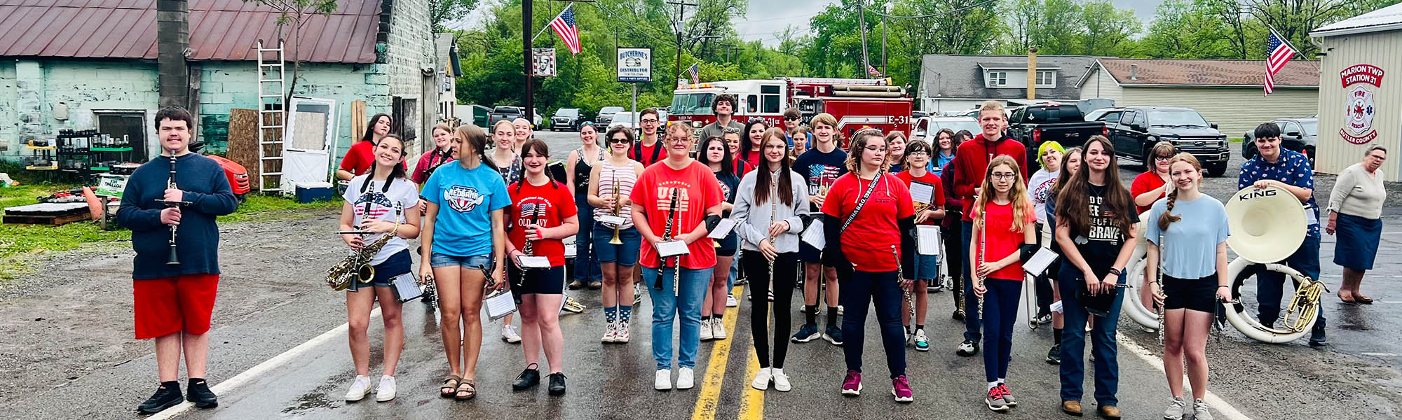 Band and Chorus members holding instruments and posing for a picture in a neighborhood street