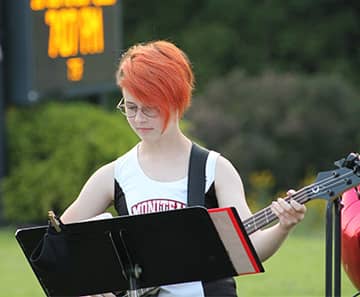 student playing a guitar