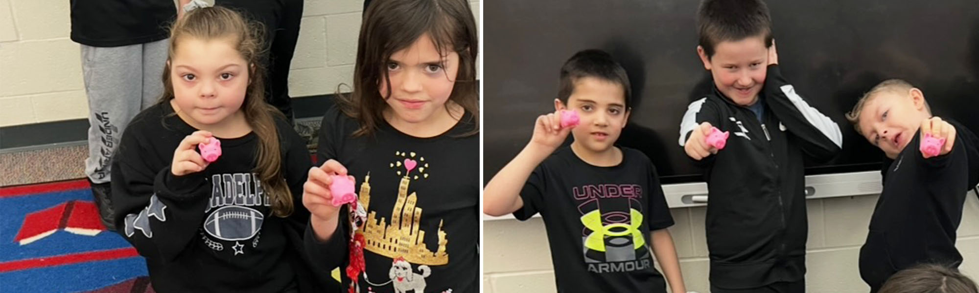 Group of students holding up little pink pig toys